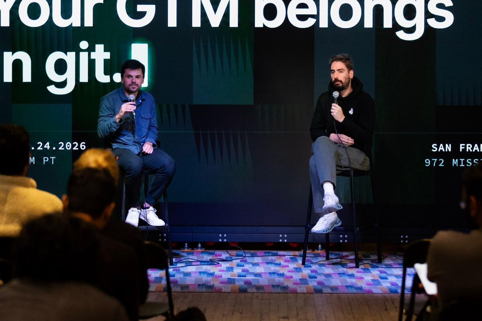 Aurelien Aubert and Noah Adelstein on stage in San Francisco under the words Your GTM belongs in git